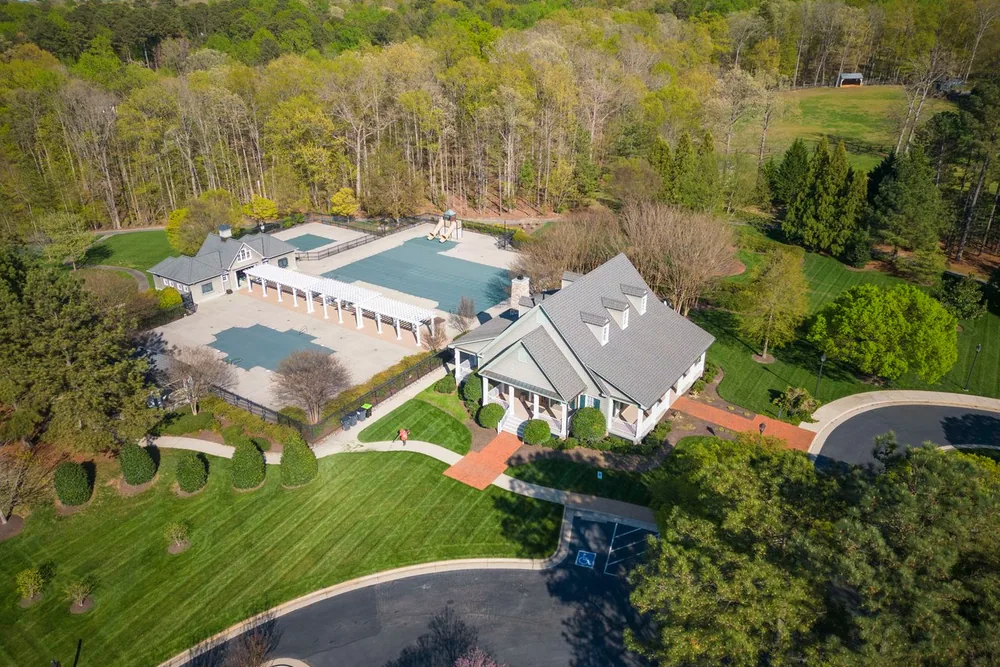Aerial view of a Midlothian neighborhood clubhouse and pool surrounded by woodland