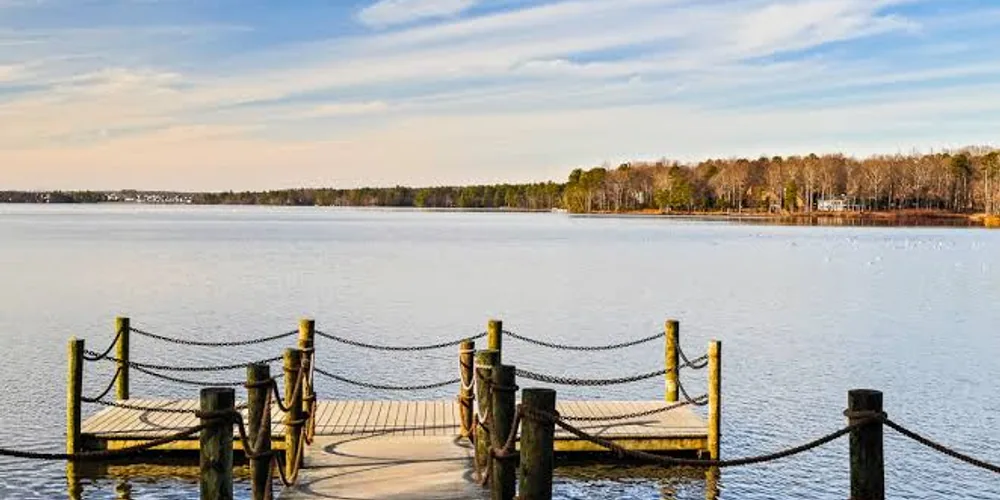 A wooden dock reaching into Swift Creek Reservoir at Brandermill, with a treeline on the far shore