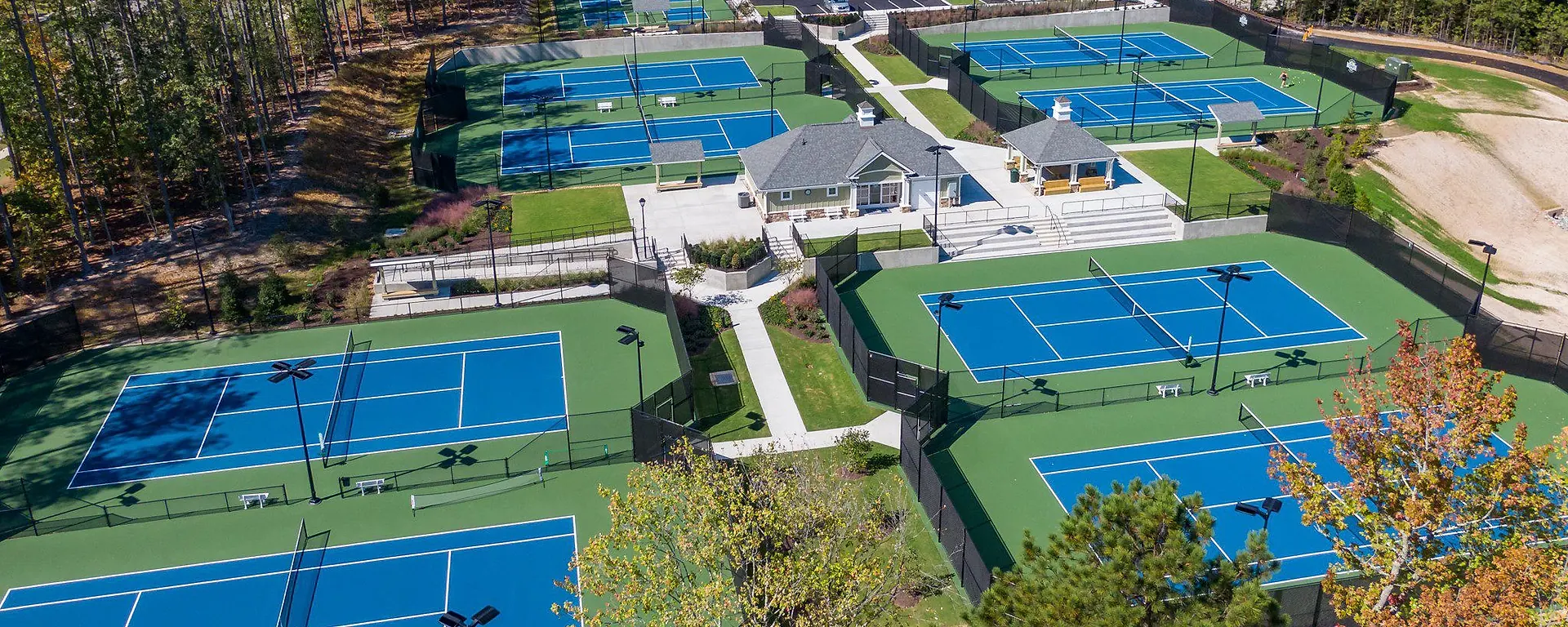Aerial view of the Magnolia Green tennis center, clubhouse, paths, and woods