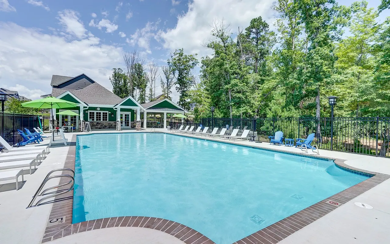 The New Market pool and green clubhouse surrounded by trees in RounTrey