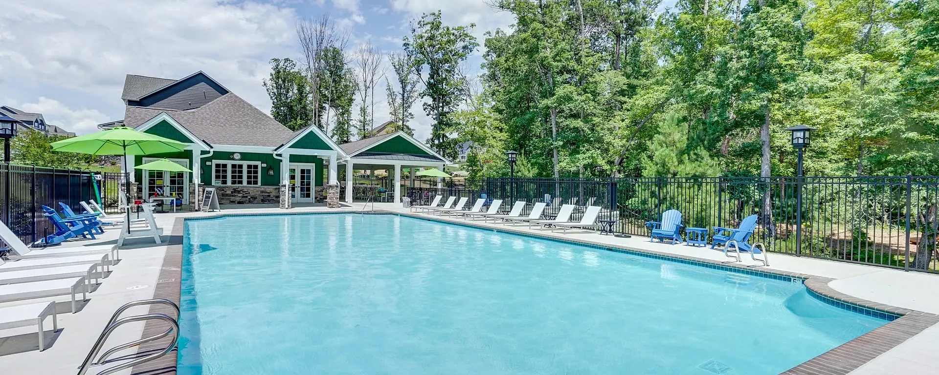 The New Market pool and green clubhouse surrounded by trees in RounTrey