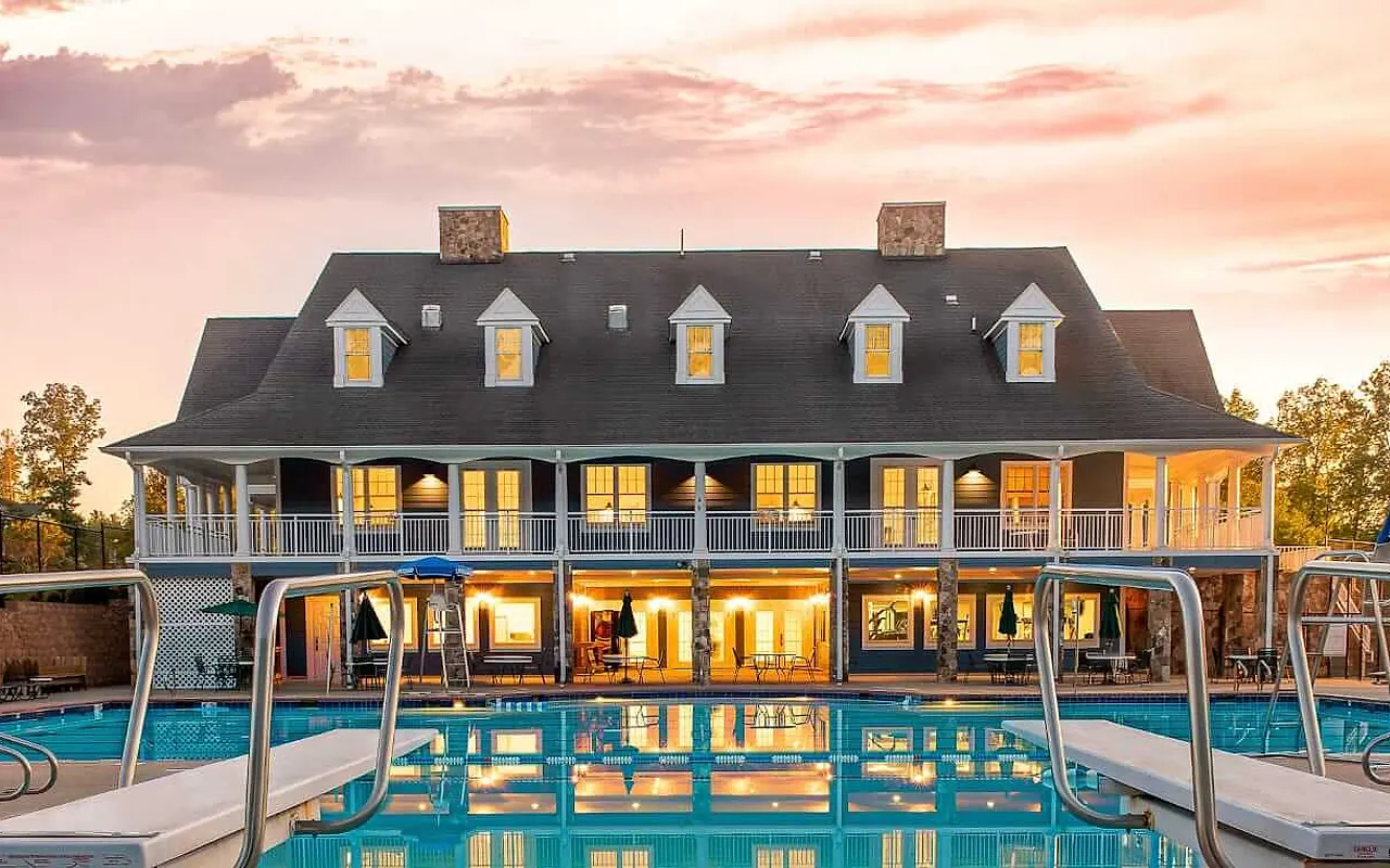 The Summer Lake clubhouse and pool reflected in the water at sunset