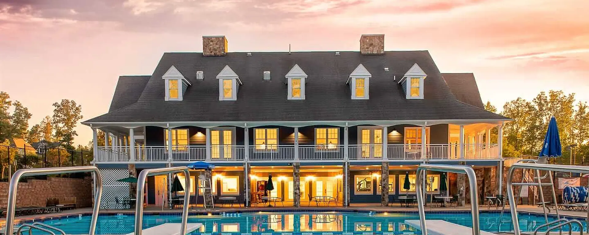 The Summer Lake clubhouse and pool reflected in the water at sunset
