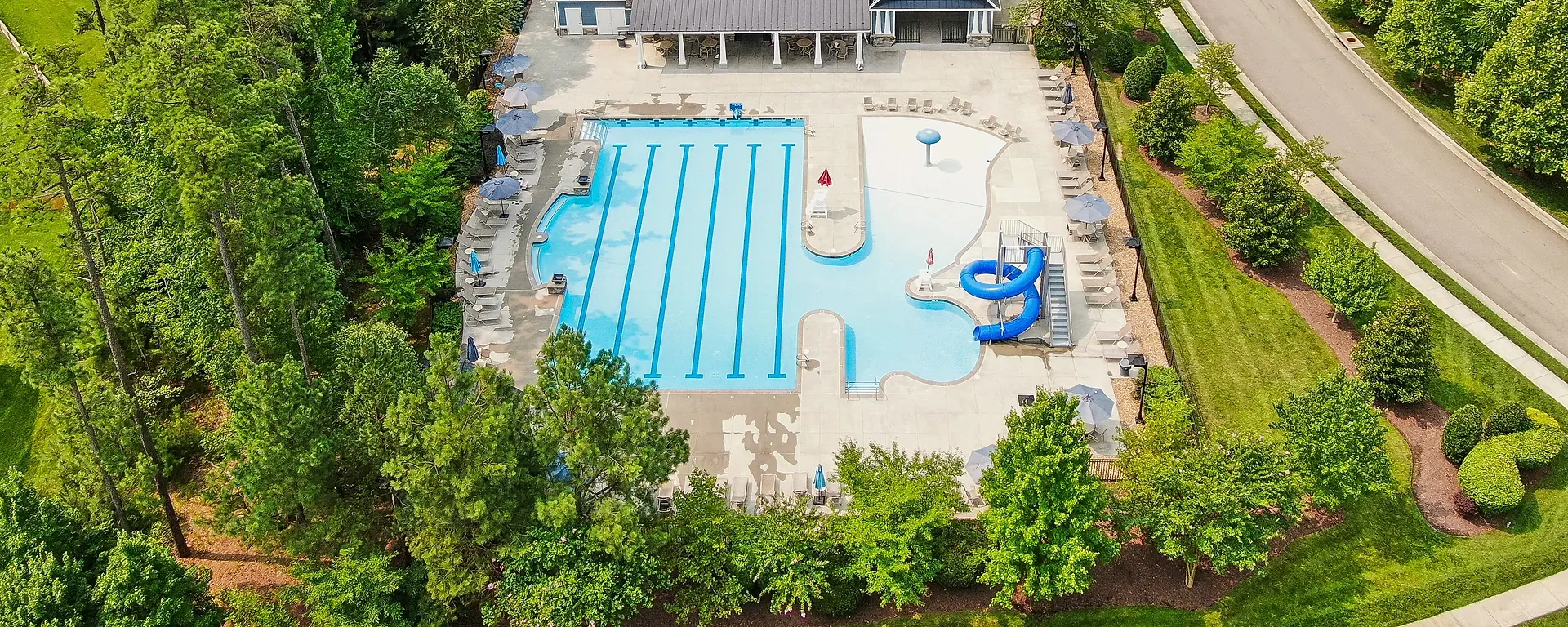 Aerial view of the Westerleigh clubhouse, pool, streets, and surrounding trees