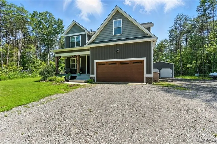 Front exterior of 275 Freestyle Lane, a white farmhouse style home with a full front porch