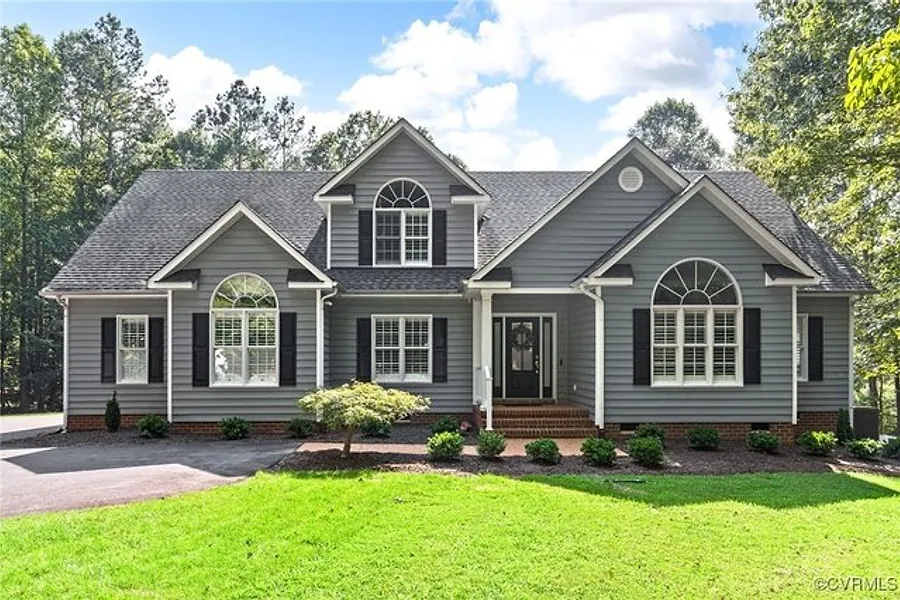 Front exterior of 3412 Lake Randolph Court, a grey two storey home on a wooded lot